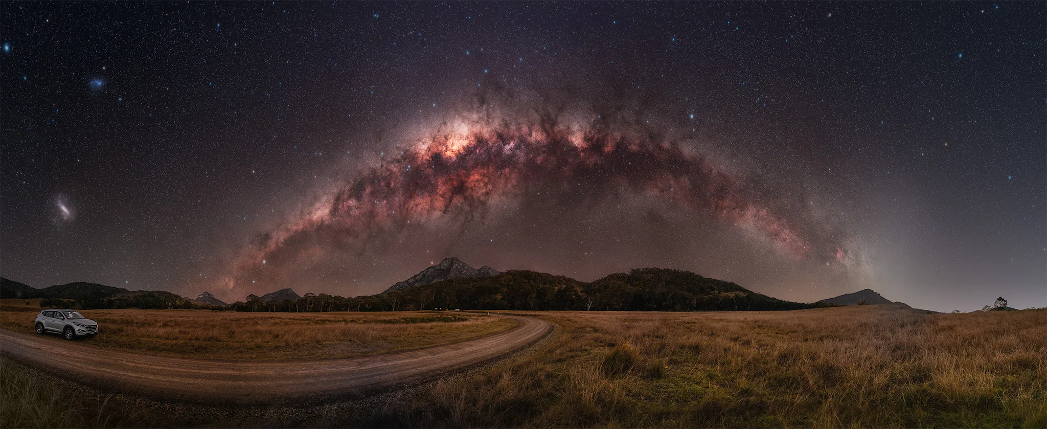 The real photograph taken at Barney Tree: a 220 degree panorama showing the Milky Way arching over Mount Barney National Park, above a gravel road and a parked car, matching the FOV Planner's simulated view